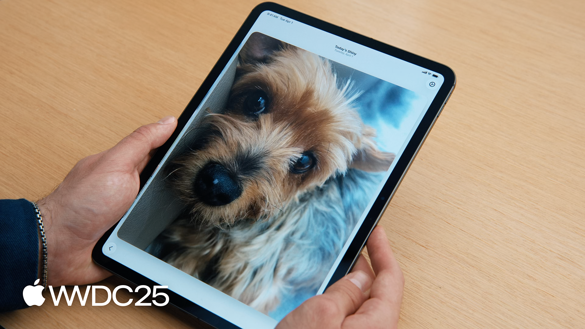 Hands holding an iPad with the image of a dog from the WWDC25 session What's new in Passkeys